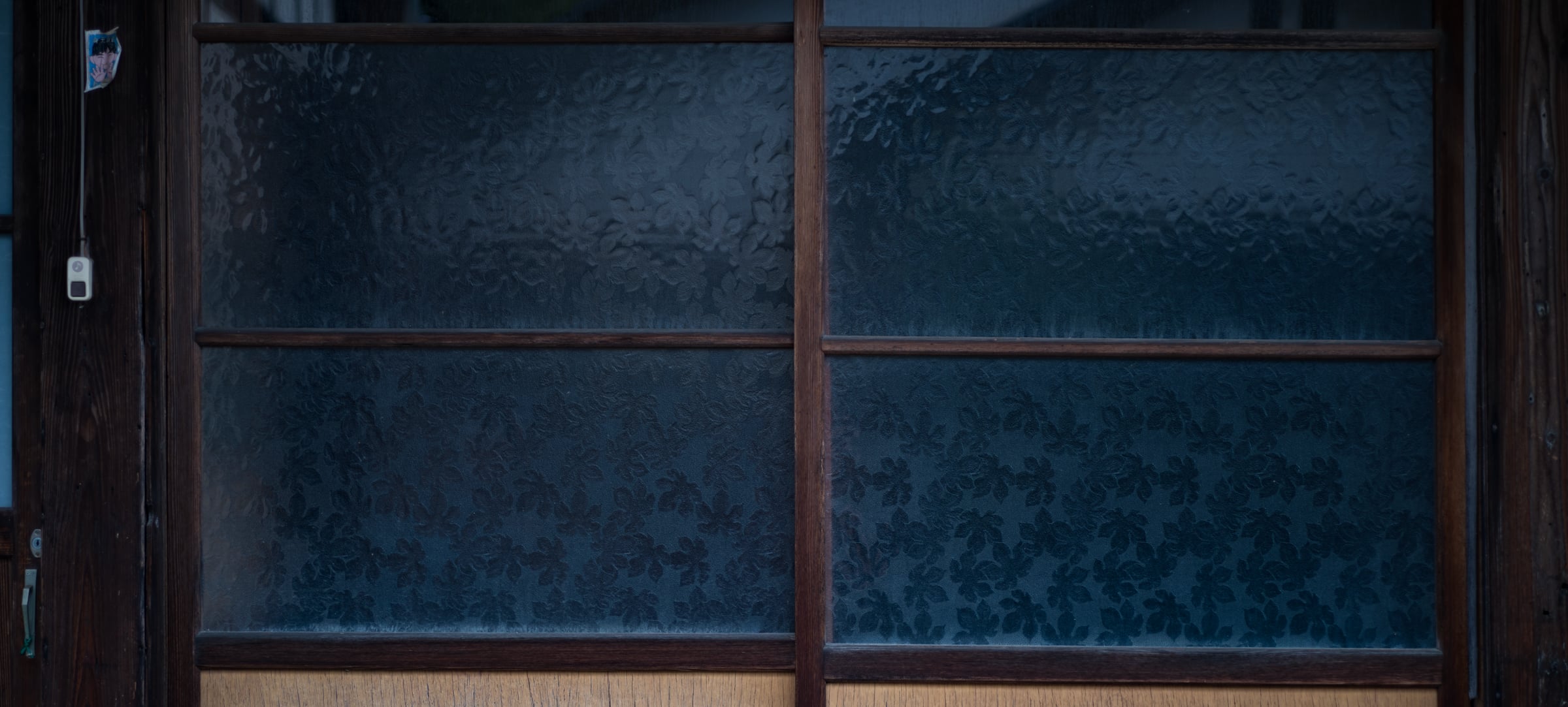 An old patterned-glass window with a floral texture in a dark wooden frame (photo: Takahiro Mitsui)