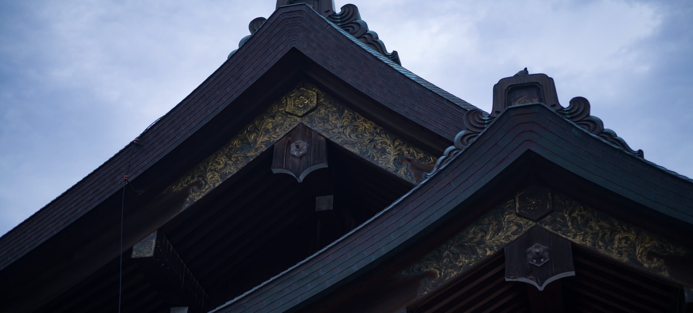 The gables of a shrine roof against a grey sky (photo: Takahiro Mitsui)