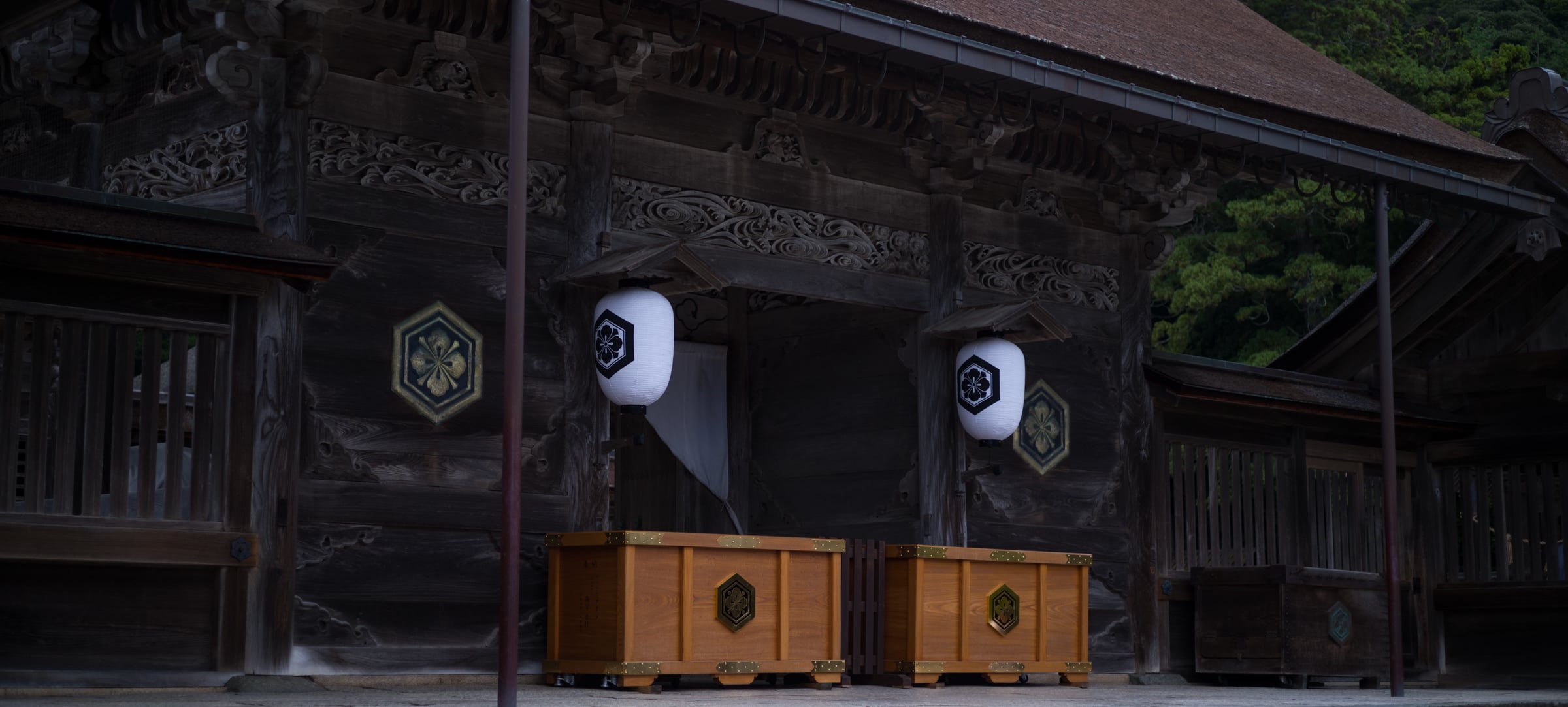 A shrine gate with white lanterns and wooden offering boxes (photo: Takahiro Mitsui)