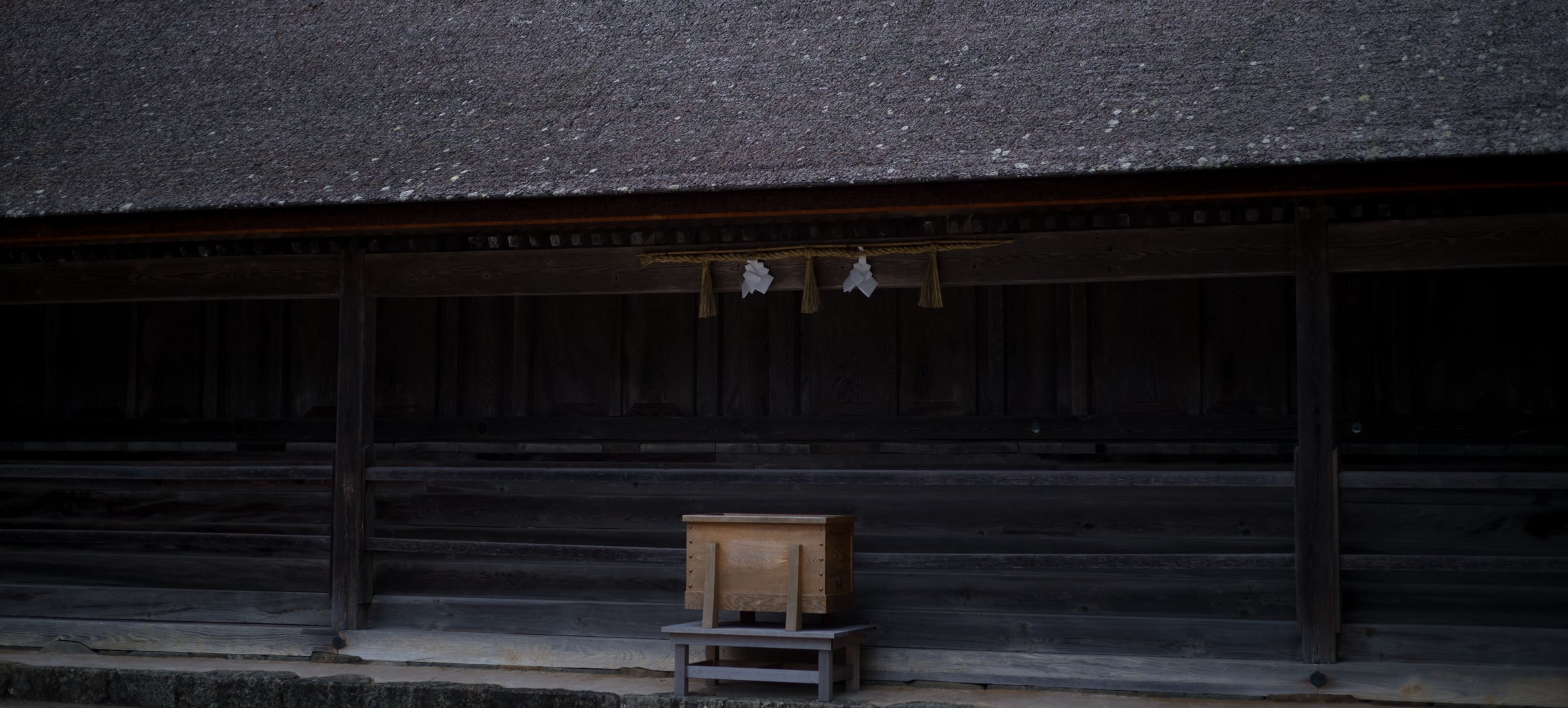 A long, low shrine hall with paper streamers hanging beneath its eaves (photo: Takahiro Mitsui)